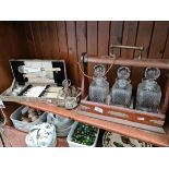 A tantalus, a boxed fish servers and a cruet set.