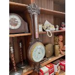 A wooden case barometer with thermometer