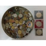 A tin containing a collection of mostly world coins.