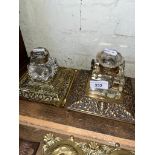 Two cut glass inkwells on ornate brass stands.