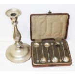 A cased set of six silver bean spoons and an eastern white metal candlestick.