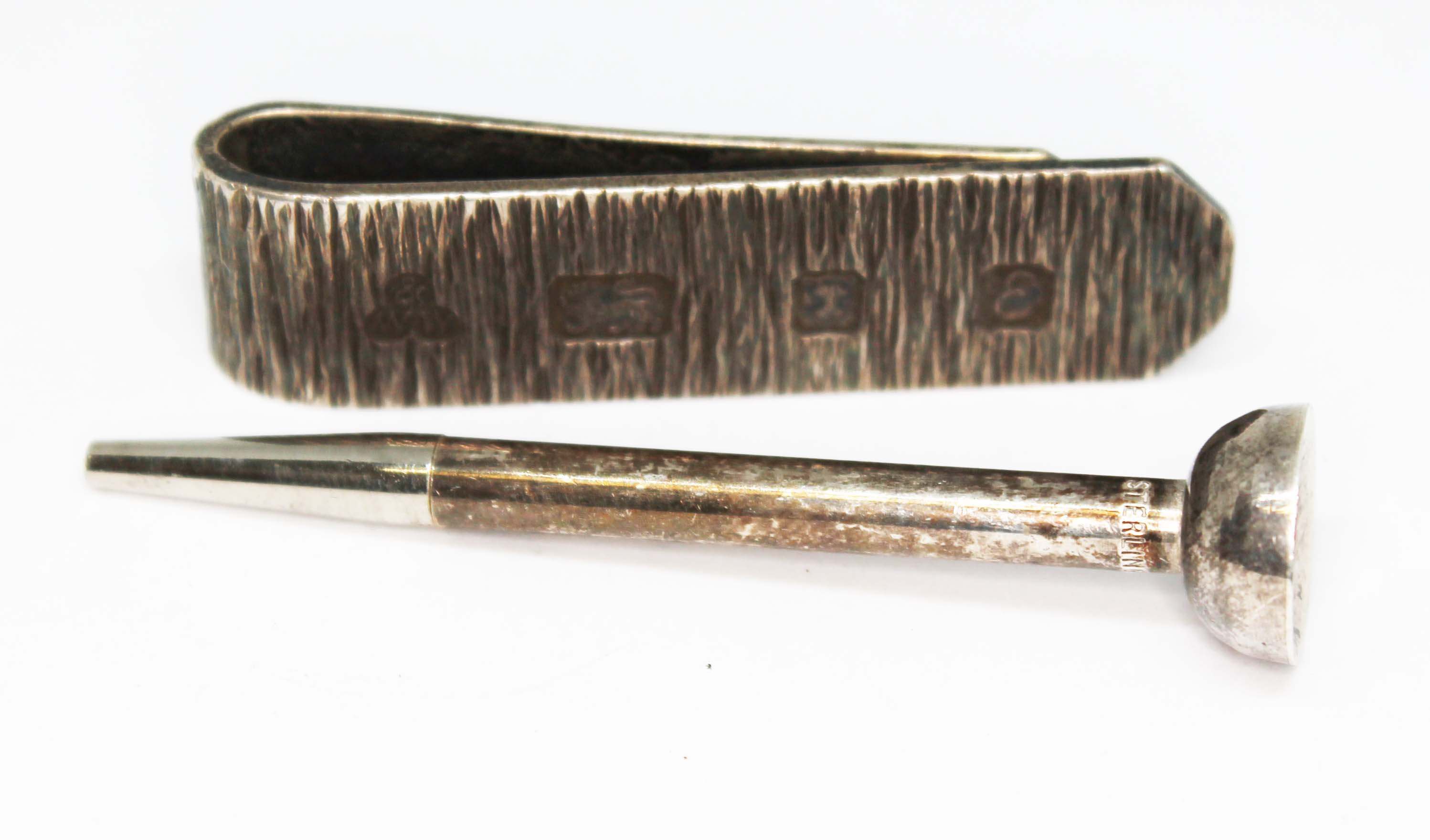 A hallmarked silver money clip and a golf tee propelling pencil marked 'Sterling Silver', gross