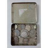 An old tin containing a collection of silver coins including, 1883 half crown, 1829 shilling, 1825