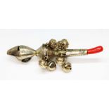 A continental white metal rattle with coral coloured teether, ten bells and whistle, marked '800'