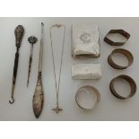 Various items of silver comprising cigarette case, three button hooks, four napkin rings, a necklace