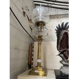 A brass Corinthian oil lamp with cut glass reservoir and etched glass shade.