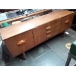 A retro teak sideboard and teak table and chairs.