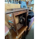 An early 20th century Jones medium CS treadle sewing machine in oak cabinet.