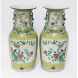 A pair of Chinese porcelain famille jaune vases, mid 19th century, decorated in over enamels with