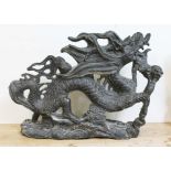 A large Chinese black stone carving, modelled as a mythical dragon on a base of clouds, 20th