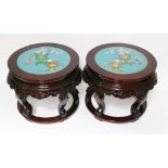 A pair of Chinese cloisonne and carved hardwood jardiniere stands, of round formed inset with a