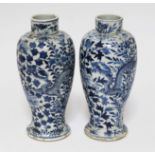 A pair of chinese blue and white porcelain baluster vases decorated with dragons, each bearing