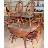 An Ercol dark elm and beech drop leaf table and four chairs.