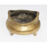 A Chinese gilt bronze incense burner, round form, twin handled and stood on three tapered feet,