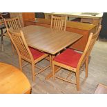 An Ercol light ash extending dining table and four chairs.