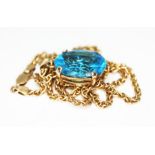 A blue topaz pendant, the oval cut stone weighing approx. 14.48ct, mounted in 9ct gold and hung on