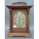 An oak cased mantle clock with arched brass dial, German three spring movement, striking on five