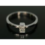 A diamond solitaire ring, the baguette cut diamond weighing approx. 0.30ct, band marked '750,