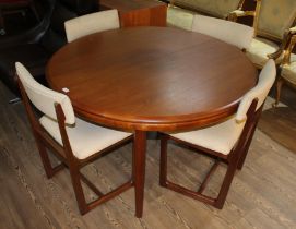 A mid 20th century teak extending dining table and four chairs, diameter 122cm.