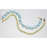 Two bracelets marked '10K', one set with blue topaz and the other peridot, lengths 18cm, gross wt.