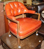 A red leather button back captain's style armchair.