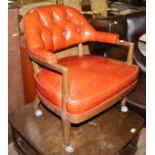 A red leather button back captain's style armchair.