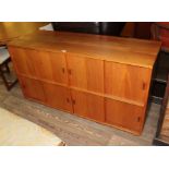 A mid 20th century teak sideboard/record cabinet with sliding doors, length 145cm.