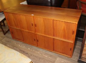 A mid 20th century teak sideboard/record cabinet with sliding doors, length 145cm.