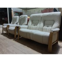 A German Himolla cream leather three piece suite comprising sofa with two matching armchairs.