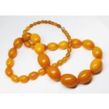 A butterscotch bakelite graduated bead necklace, clasp marked '9K', gross wt. 86.5g, length 71cm.