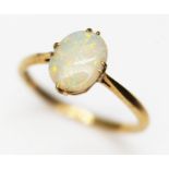 An opal cabochon ring, the oval flat bottom cabochon measuring approx. 9.5mm x 6.5mm, marked '18ct',