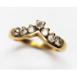 A hallmarked 18ct gold seven stone diamond wishbone ring, gross wt. 4.1g, size K.