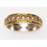 A two colour eternity band set with colourless stones, marked '18CT', gross wt. 4.5g, size P.