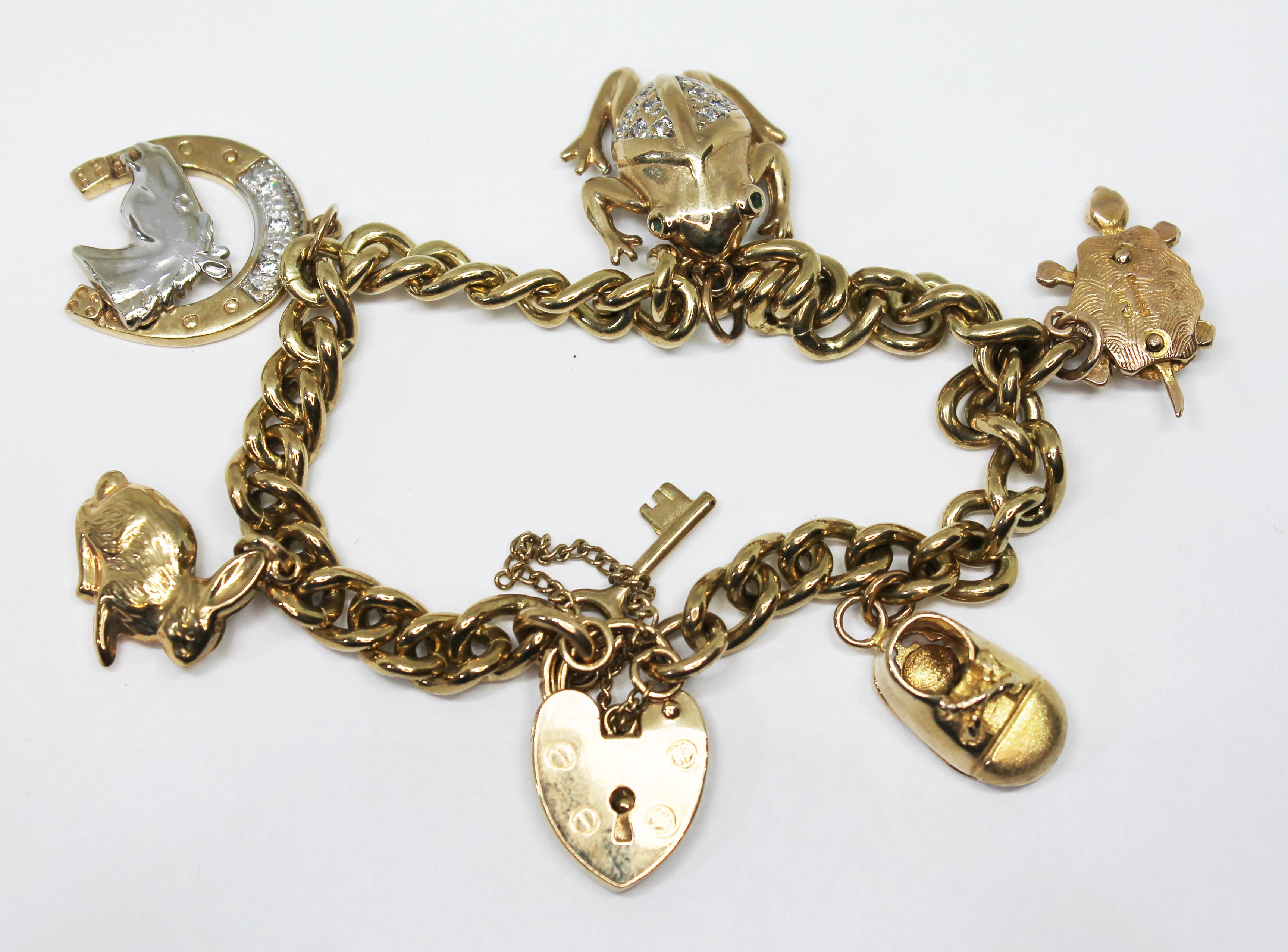 A hallmarked 9ct gold charm bracelet, gross wt. 34.4g.