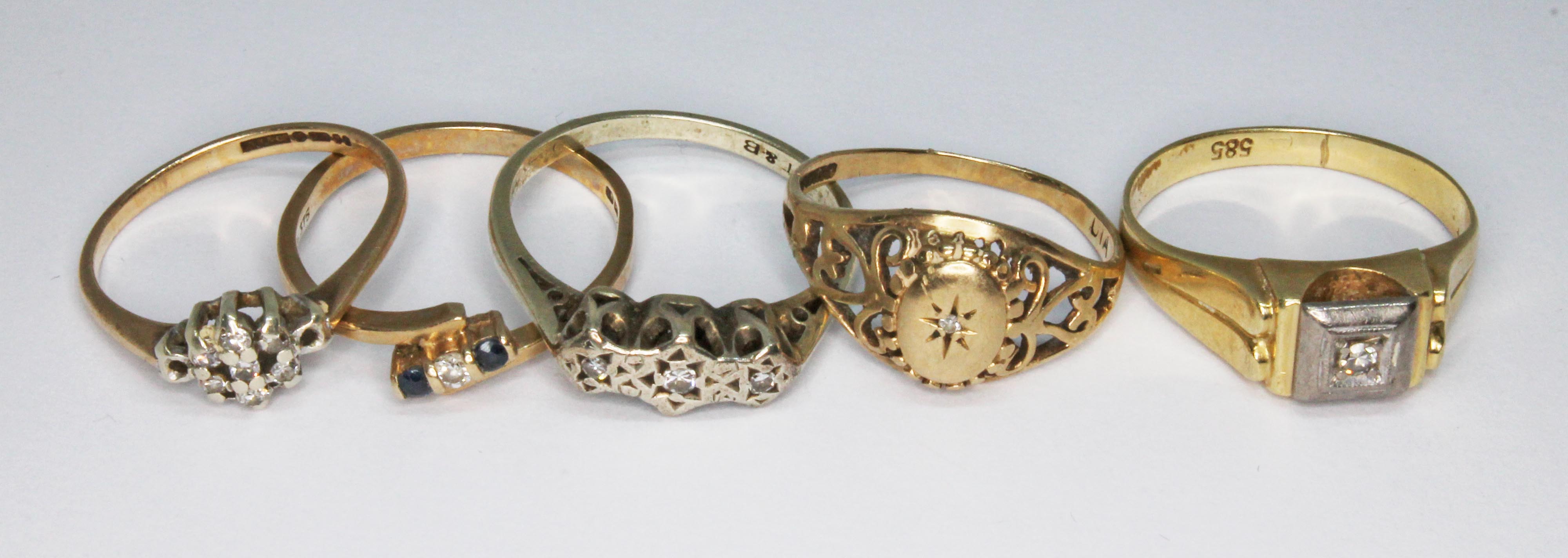 A group of five assorted rings comprising four marked '375' wt.5.5g, and another marked '585' wt.