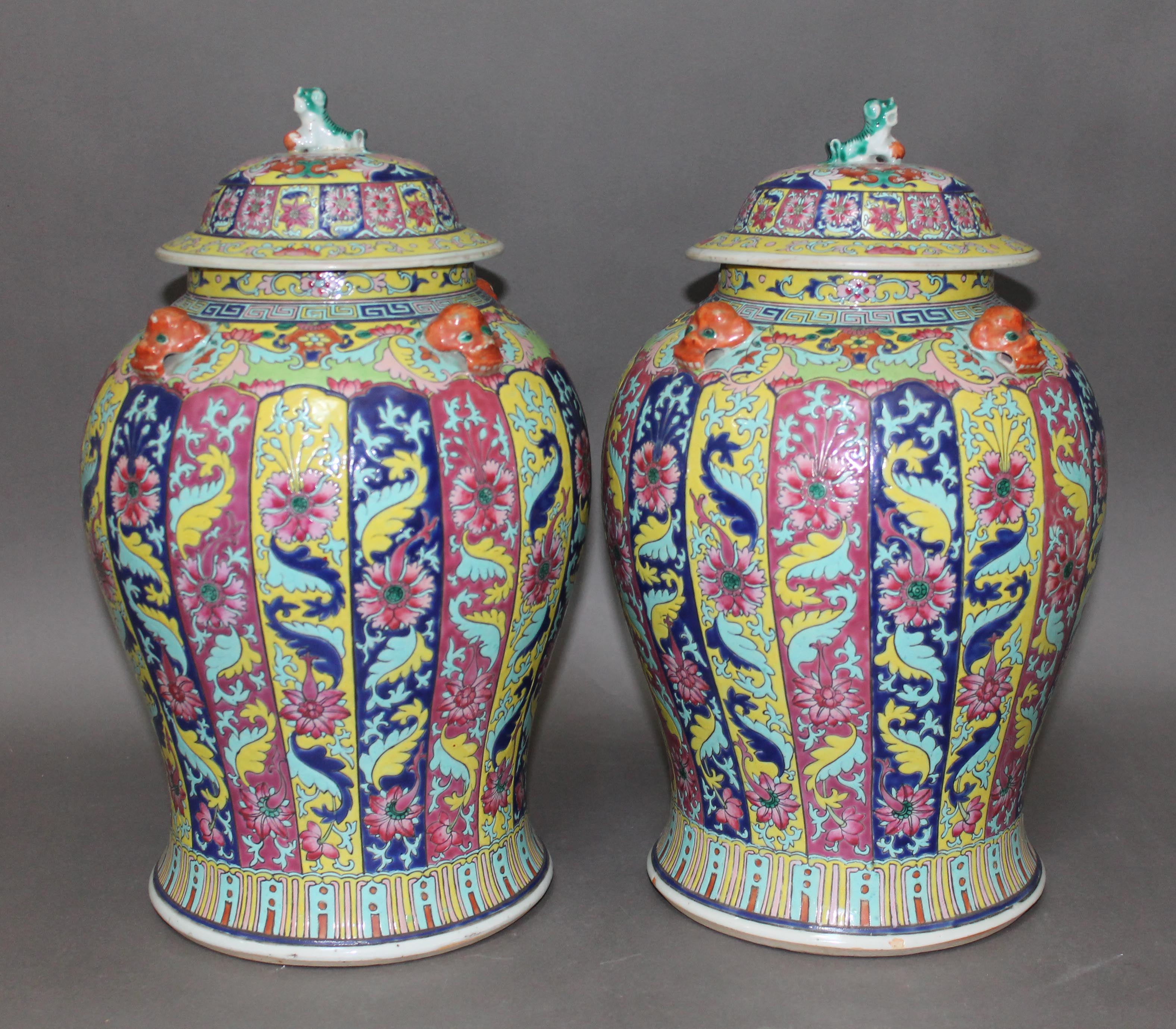 A pair of Chinese Famille Rose porcelain vases, mid 19th century, of baluster form, covers with lion