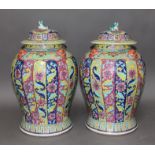 A pair of Chinese Famille Rose porcelain vases, mid 19th century, of baluster form, covers with lion