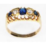 An antique hallmarked 18ct gold ring set with two diamonds, two sapphires and central blue paste,