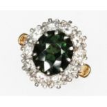 A fancy sapphire and diamond cluster ring, the central slightly oval cut green stone weighing