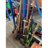 A collection of garden tools and drain rods and brushes
