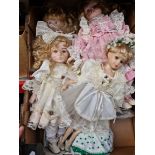 A box containing a collection of bisque headed dolls.