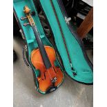 A cased modern violin and a music stand