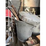 A galvanised dust bin containing various tools.