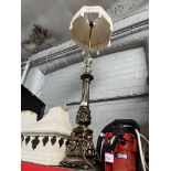 A metal standard decorative lamp with tasseled shade.