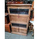 An early 20th century mahogany and leaded glass sectional bookcase with bureau and drawers.