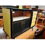 A 1950s sideboard with sliding glass doors, melamine top and Smith's clock surmount.