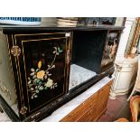 A Chinese black lacquer side cabinet decorated with flowers in carved stone relief.