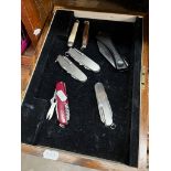 A tray containing 7 penknives.