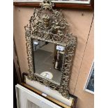 A cast brass framed ornate mirror.