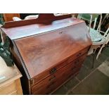 A George III mahogany bureau standing on ogee bracket feet, some later elements.